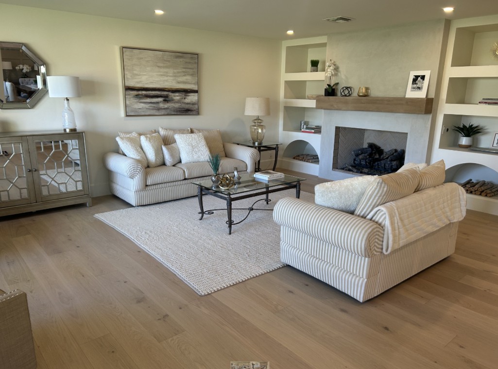 Replace vinyl with hardwood flooring — living room with new wide-plank hardwood floors and fireplace