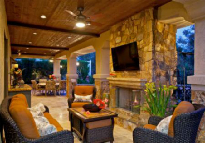 Outdoor patio with fireplace, TV, and twilight views