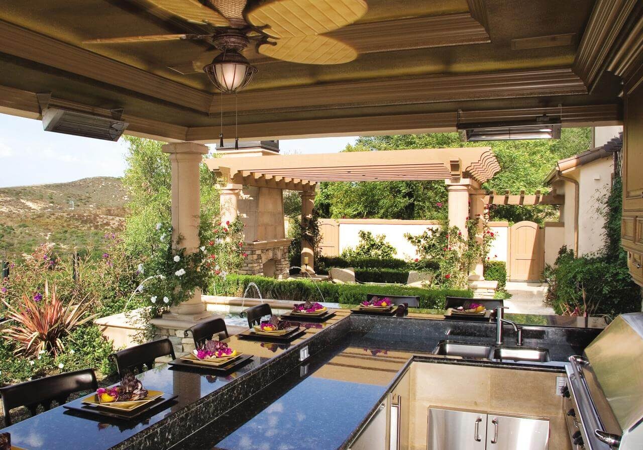 Covered outdoor kitchen with stone columns and pergola